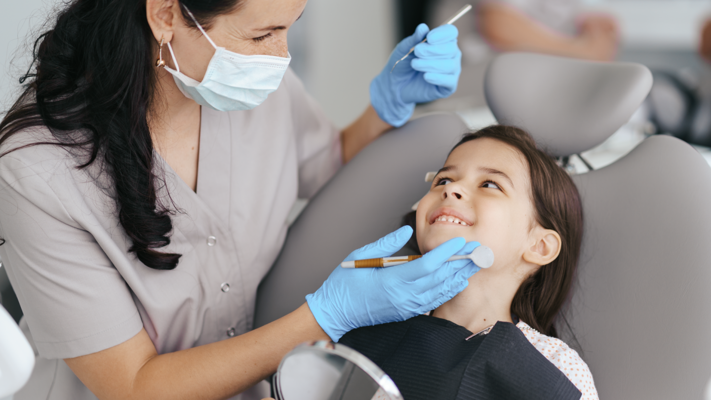 Profissional de Odontologia cuidando da saúde bucal da criança